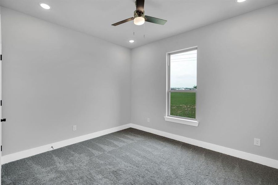 Carpeted empty room with ceiling fan