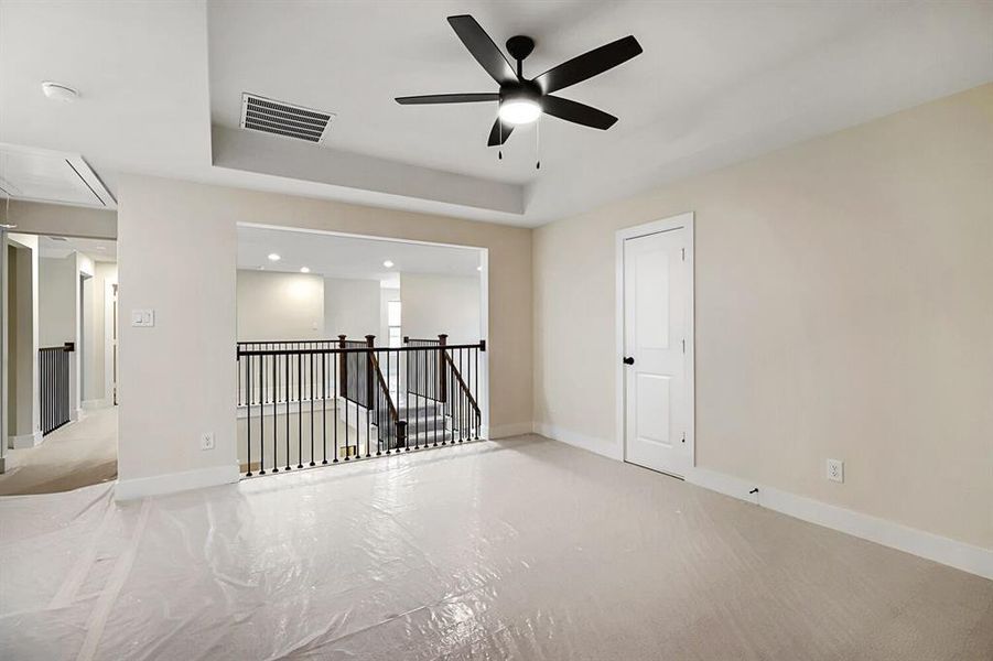 Empty room with a tray ceiling and ceiling fan Empty room with a tray ceiling and ceiling fan