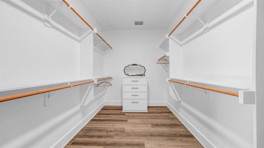 Primary bedroom walk in closet with built-in shelving & drawers