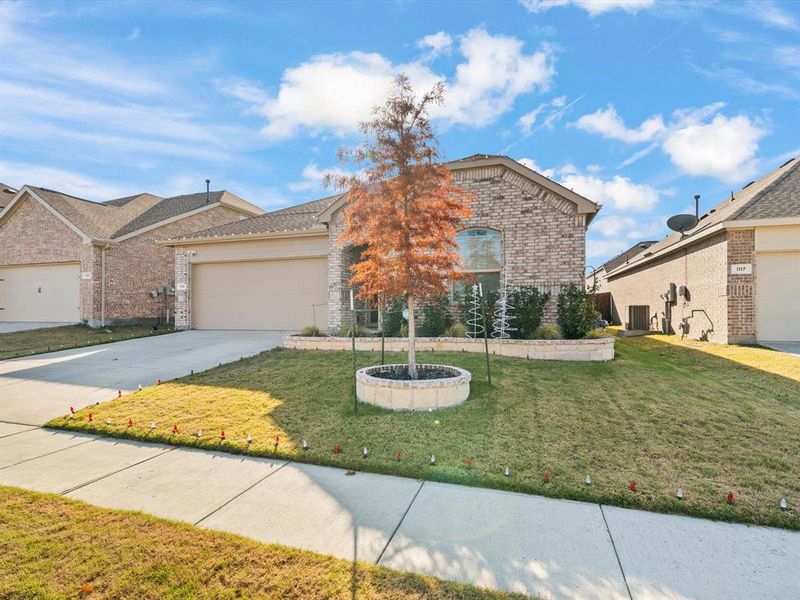 View of property with central AC, a front lawn, and a garage