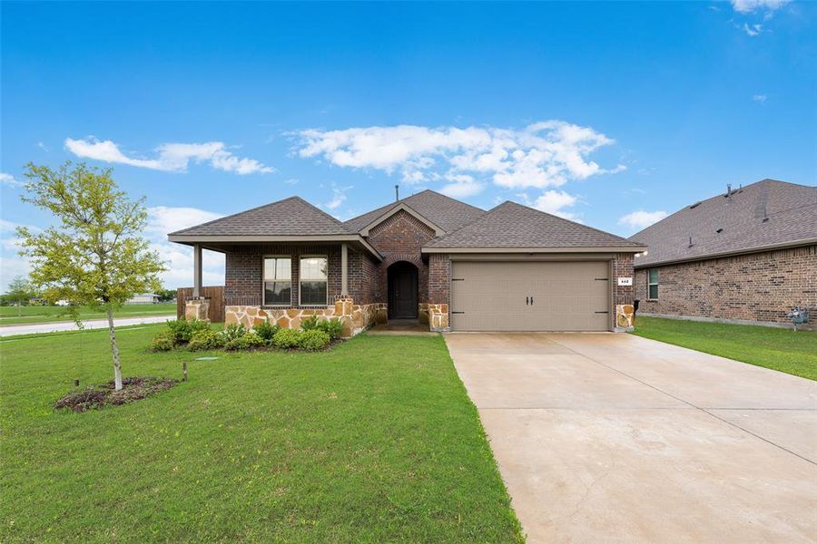 Ranch-style home with driveway, a front yard, brick siding, and a garage