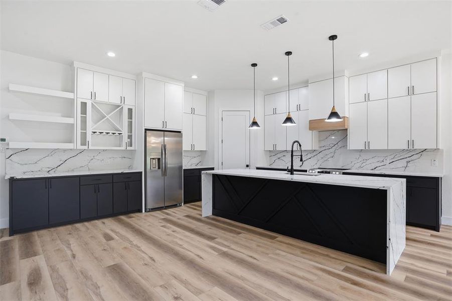 Contemporary kitchen featuring a large central island with waterfall-edge countertop