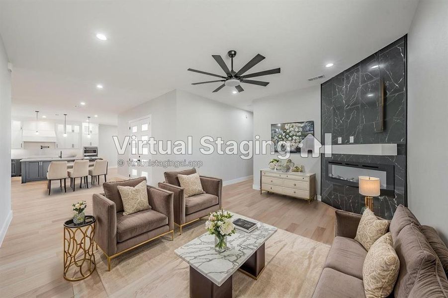 Living room with light wood-type flooring, ceiling fan, recessed lighting, and a fireplace