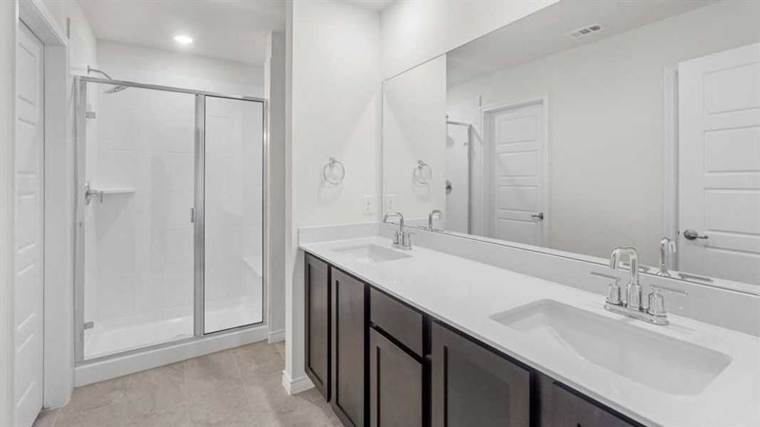 Full bathroom featuring a shower stall, double vanity, recessed lighting, and light tile patterned floors Full bathroom featuring a shower stall, double vanity, recessed lighting, and light tile patterned floors