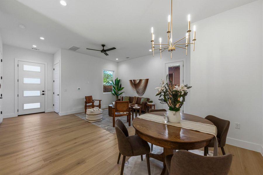 Dining room featuring ceiling fan, light wood-style floors, and a chandelier