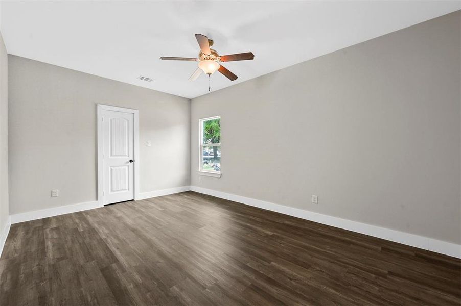 Unfurnished room with ceiling fan and dark wood-type flooring