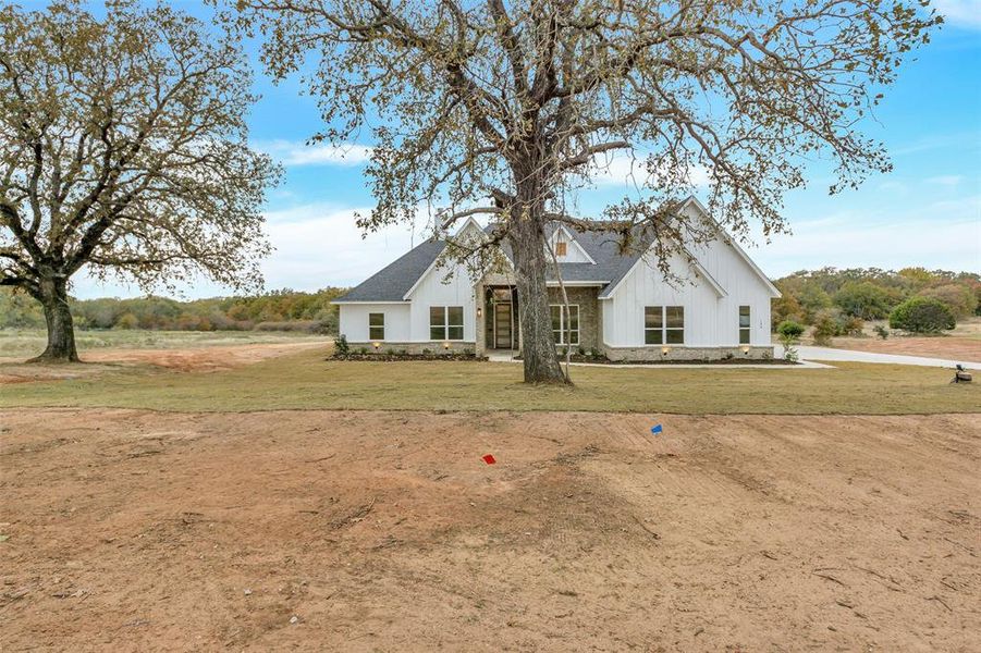 Modern farmhouse style home with a front yard