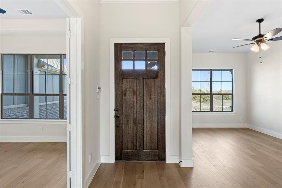 Entrance foyer with ceiling fan and light wood-type flooring