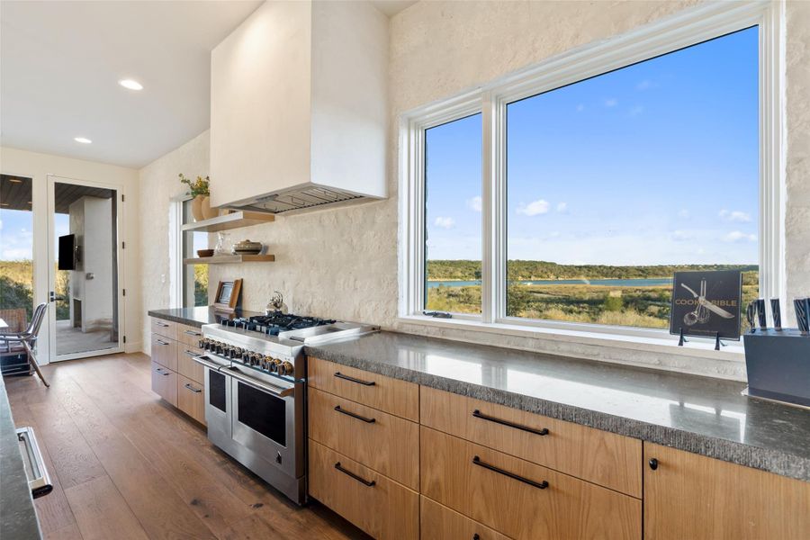 Kitchen with range with two ovens, plenty of natural light, dark wood-style flooring, open shelves, and recessed lighting