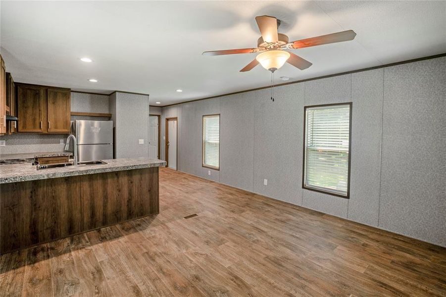 Kitchen featuring freestanding refrigerator, wood finished floors, plenty of natural light, a ceiling fan, and recessed lighting