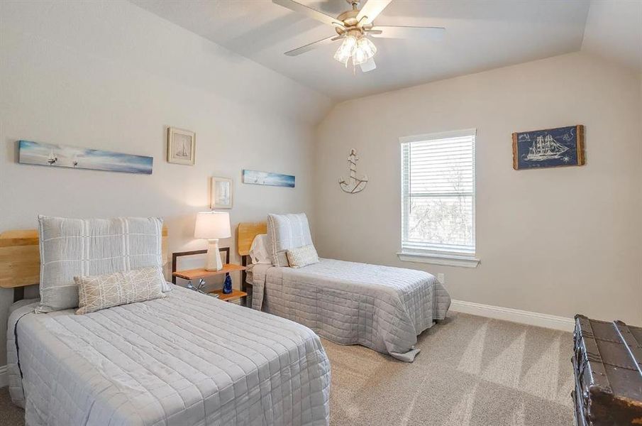 Bedroom featuring ceiling fan, carpet flooring, and vaulted ceiling