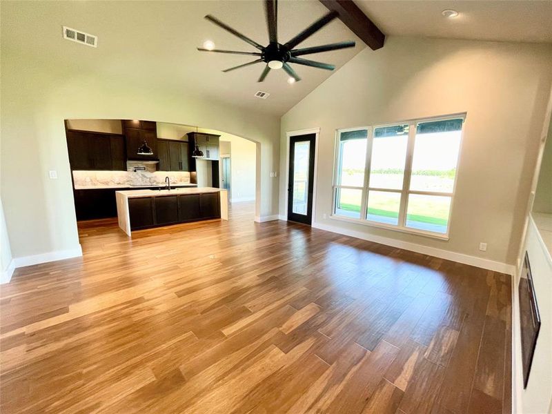 Kitchen featuring beam ceiling, high vaulted ceiling, and light hardwood / wood-style flooring