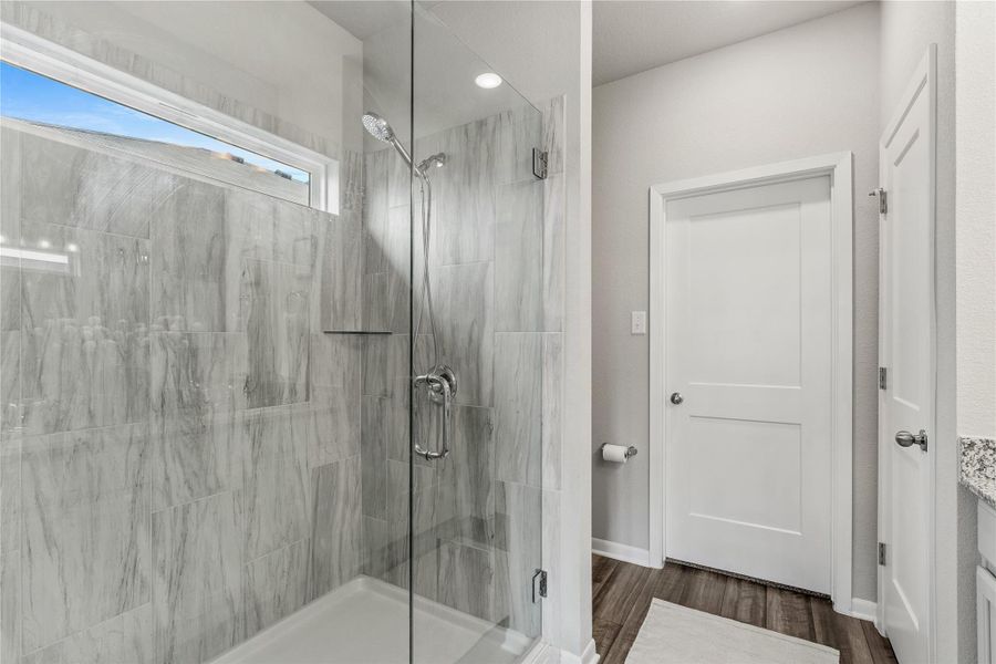 A well-appointed shower space showcases sleek glass doors and stylish gray tile. A well-appointed shower space showcases sleek glass doors and stylish gray tile.