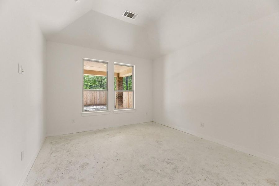 Retreat to a peaceful primary bedroom featuring an elevated, vaulted ceiling and two large windows overlooking the serene backyard, perfect for relaxing mornings and restful nights. Retreat to a peaceful primary bedroom featuring an elevated, vaulted ceiling and two large windows overlooking the serene backyard, perfect for relaxing mornings and restful nights.