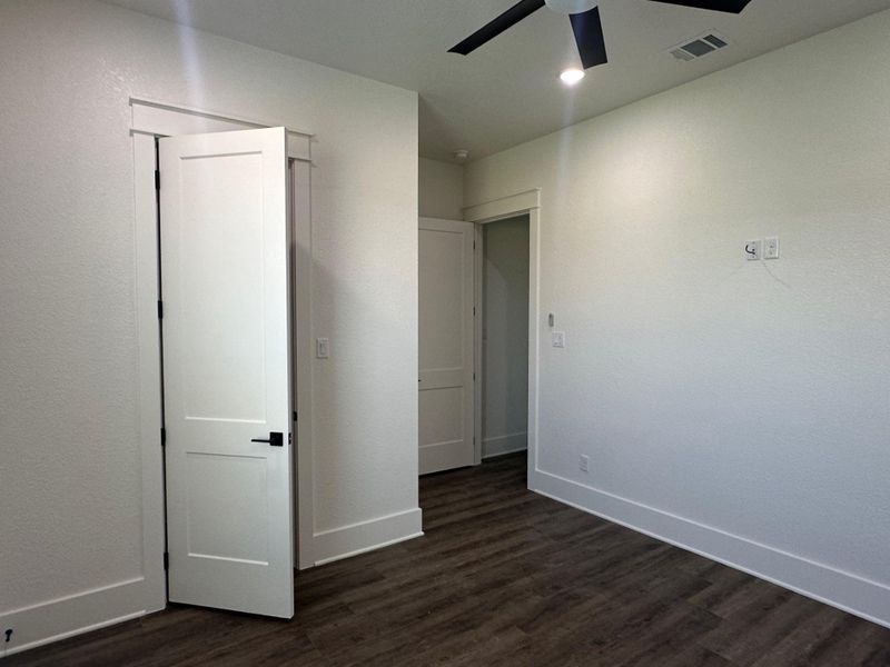 Unfurnished bedroom with dark wood-type flooring and a ceiling fan