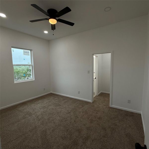 Bedroom featuring neutral-toned carpet flooring, a ceiling fan with integrated lighting, and recessed lighting