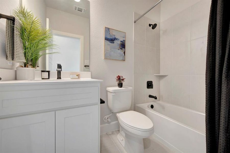 Full bathroom featuring a white vanity with a rectangular sink, quartz countertop, and matte black faucet