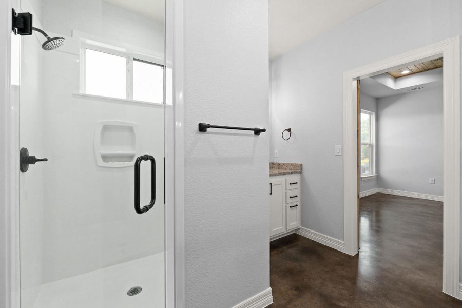 Bathroom featuring a stall shower, concrete floors, and vanity