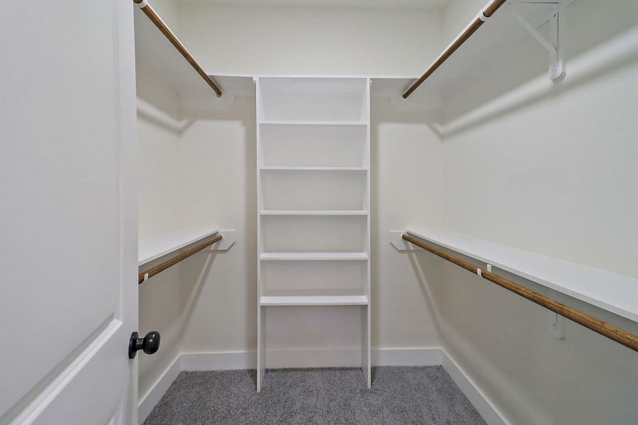 The walk in closet has lots of room and shelving for all your items.