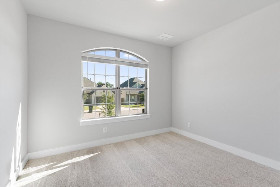 Empty room featuring light carpet and baseboards