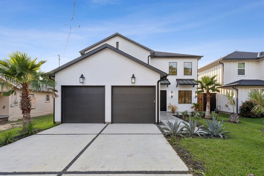 View of front of home with a front yard and a garage