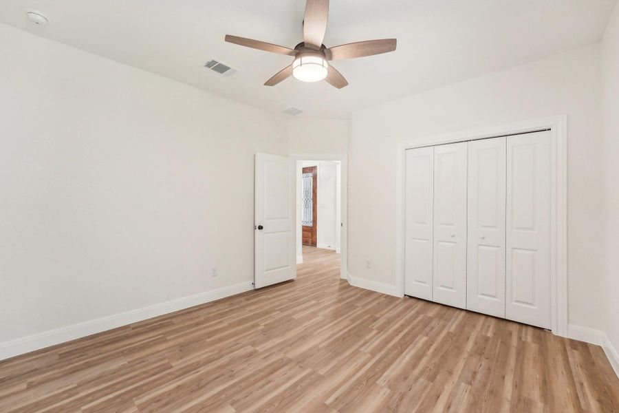 Bedroom 3 with visible vents, wood plank vinyl floor, a closet, baseboards, and ceiling fan Bedroom 3 with visible vents, wood plank vinyl floor, a closet, baseboards, and ceiling fan