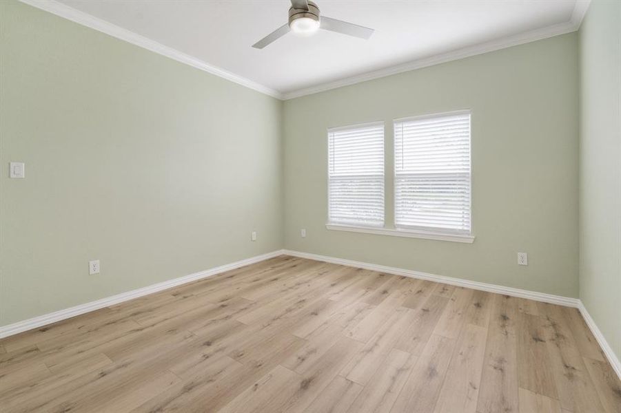 Unfurnished room featuring light hardwood / wood-style floors, ceiling fan, and crown molding