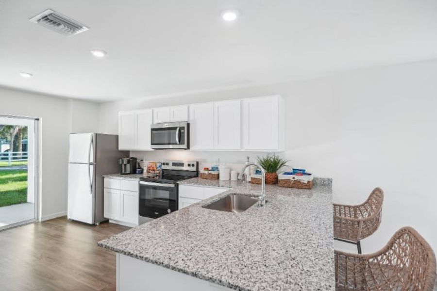 A kitchen with white cabinets.