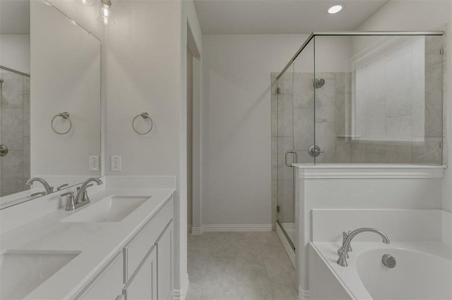 Bathroom featuring a double vanity with integrated sinks, a walk-in shower with clear glass enclosure and tiled walls, a built-in soaking tub, and contemporary brushed nickel fixtures