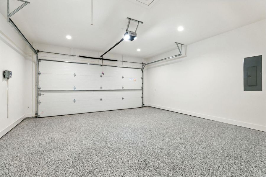 Garage featuring electric panel, recessed lighting, and a garage door opener Garage featuring electric panel, recessed lighting, and a garage door opener