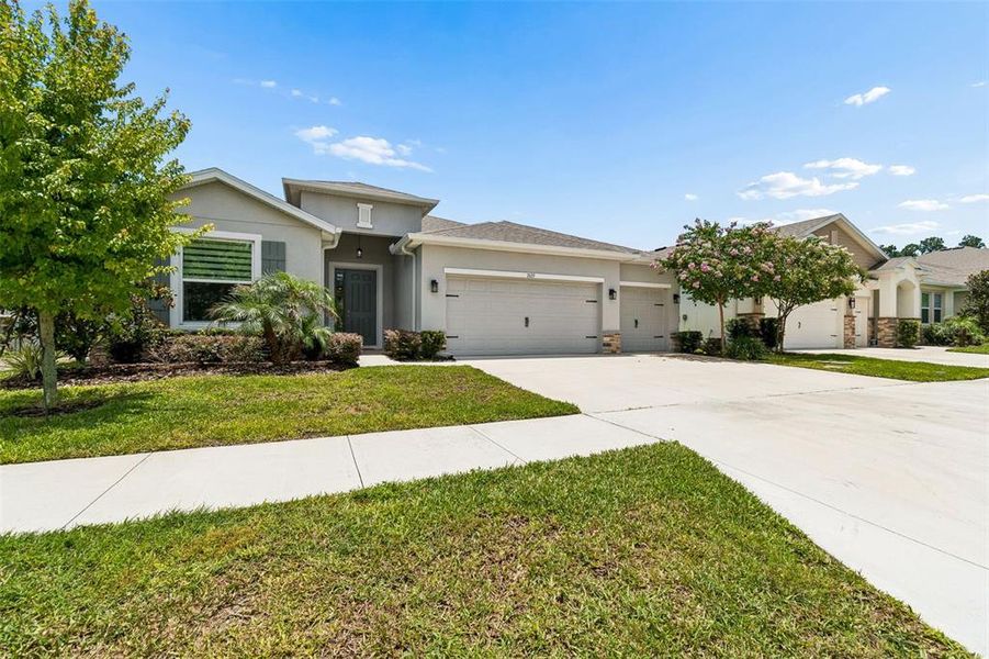 Front exterior of a new home in Deerbrook, Land O' Lakes, FL, highlighting curb appeal (Image 27).