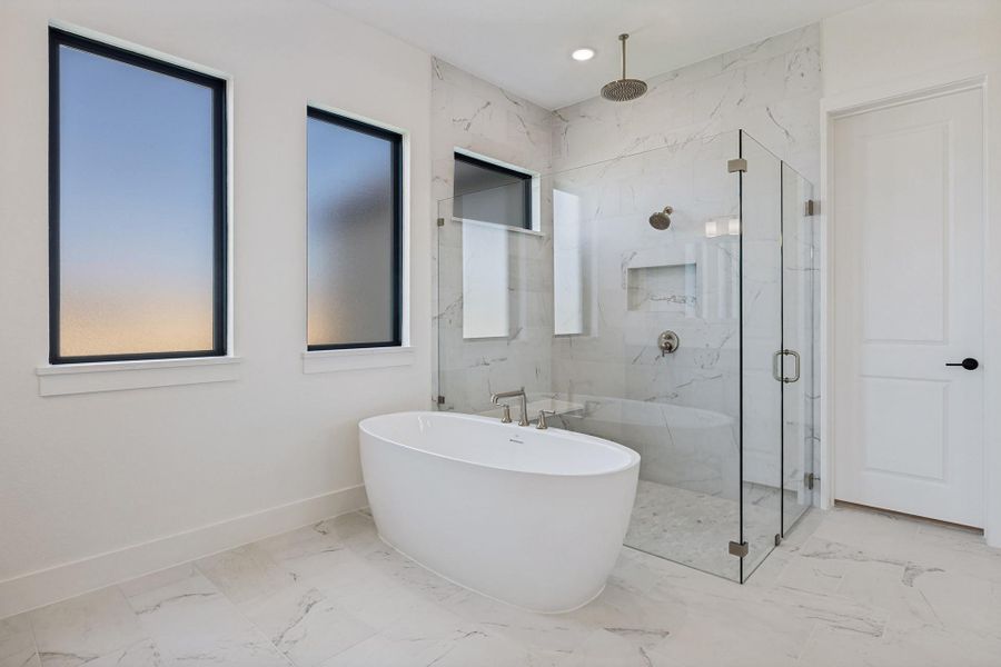 Marble-style tile floors and a glass-enclosed shower anchor this contemporary bathroom.