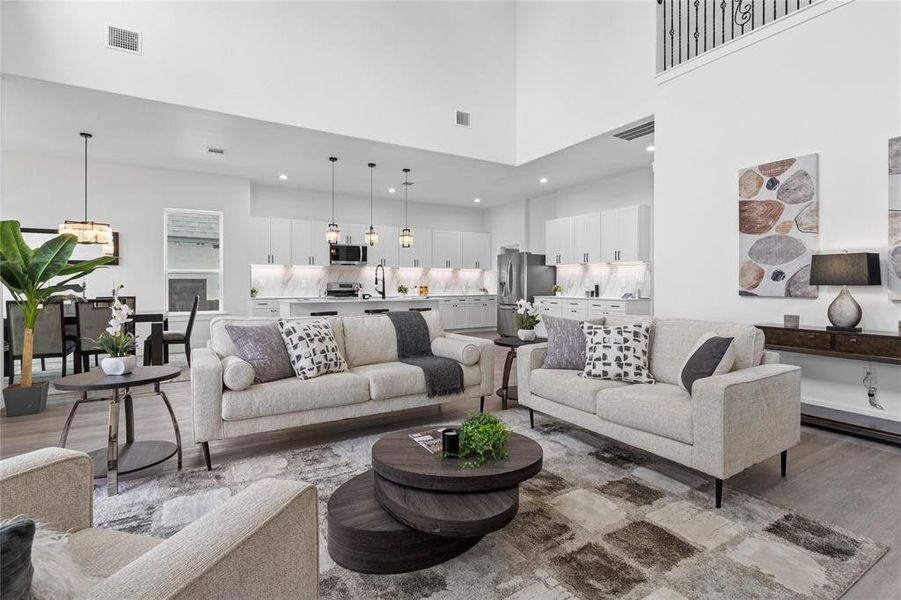 Living room featuring wood finished floors and a towering ceiling Living room featuring wood finished floors and a towering ceiling