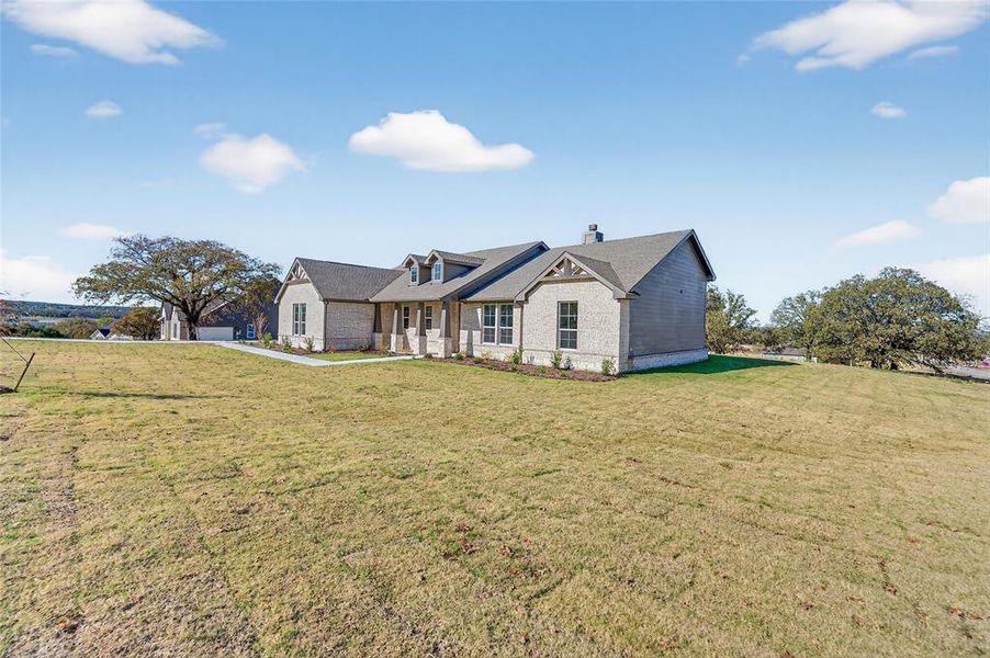 View of front facade featuring a chimney, a front lawn, and covered porch View of front facade featuring a chimney, a front lawn, and covered porch