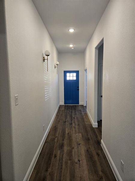 Doorway with wood finished floors and baseboards