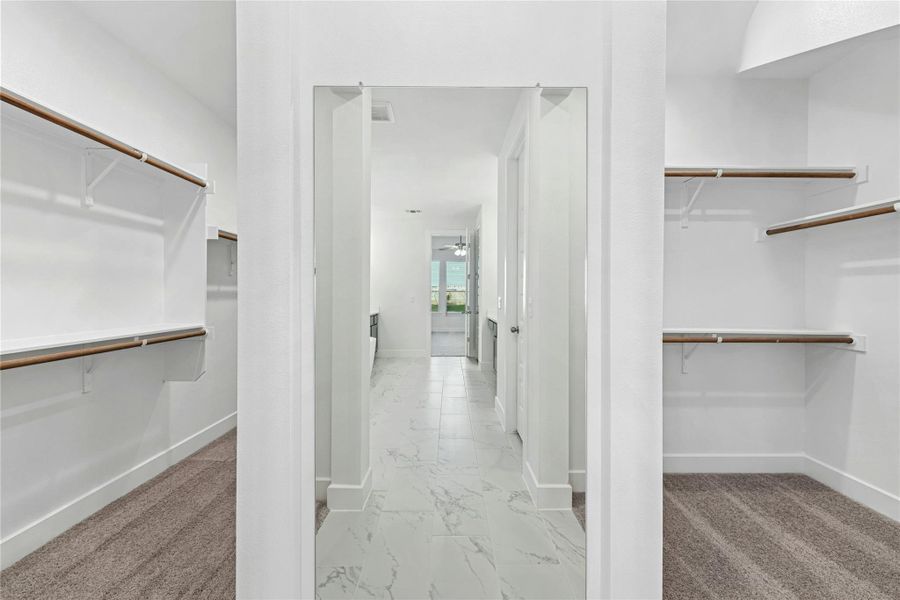Spacious closet with light marble finish flooring and ceiling fan