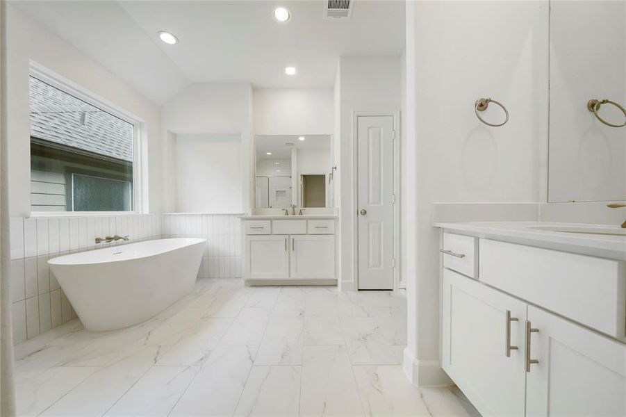 Step into the spa-like Primary Bath! The space features two vanities, custom cabinets, and stunning quartz countertops. (Sample photos of a completed Chesapeake floor plan. The image may feature alternative selections and/or upgrades.