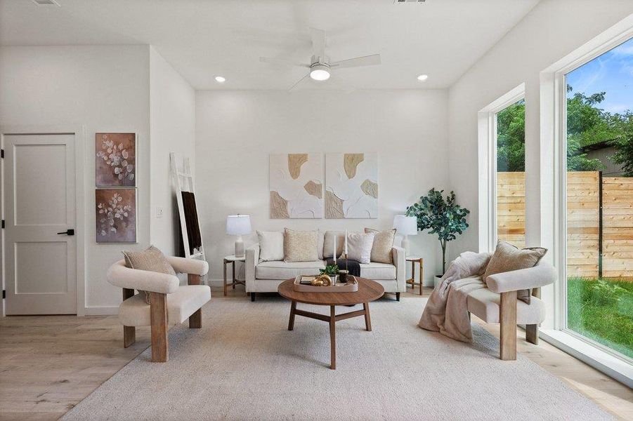 Living area featuring light wood flooring, recessed lighting, and a ceiling fan
