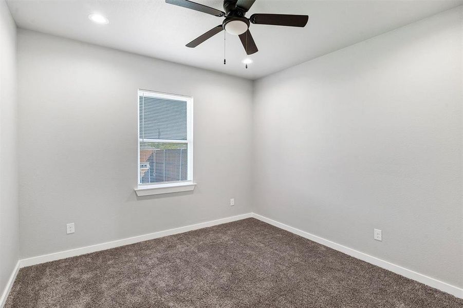 Carpeted spare room with ceiling fan