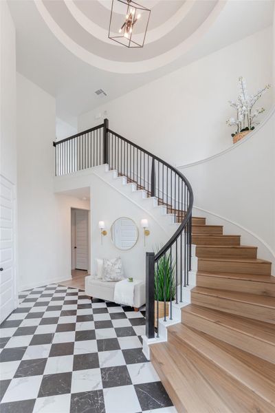 Cathedral ceiling, curved staircase, and eye-catching custom tile flooring