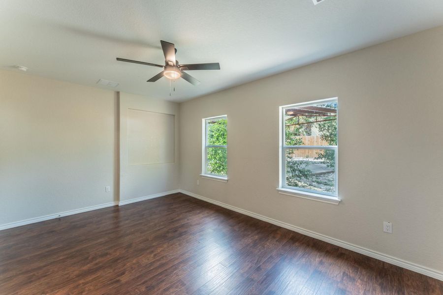 Room featuring wood-finish flooring, neutral wall tones, and a ceiling fan with integrated lighting