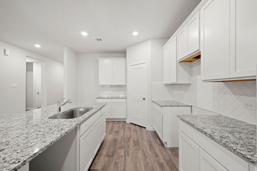 A kitchen with white cabinets.