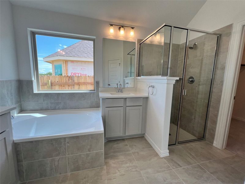 Full bathroom with vanity, a garden tub, a stall shower, and tile patterned flooring Full bathroom with vanity, a garden tub, a stall shower, and tile patterned flooring