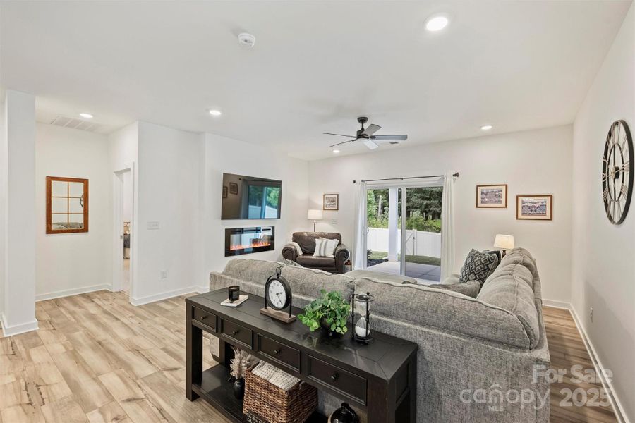 This ample great room is spacious enough for a large sectional sofa.  The focal point is the cozy electric fireplace that is controlled by remote.  The sliding doors exit to the covered porch overlooking the private backyard.