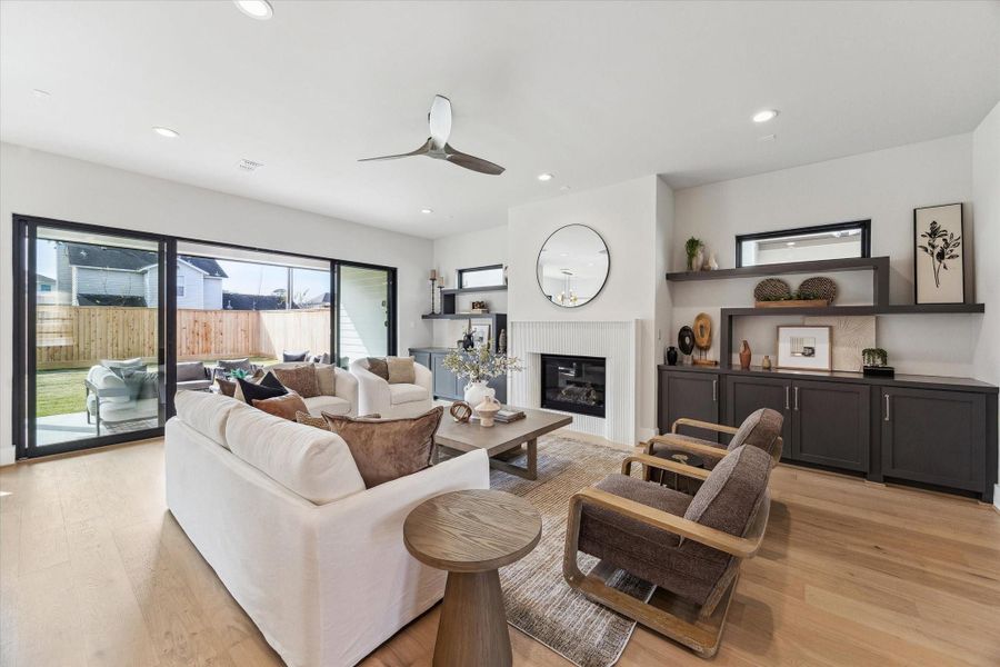 Living area features a cozy cast stone fireplace and modern built-in shelving.