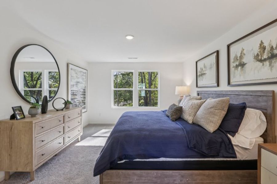 A bedroom with a bed and a mirror.