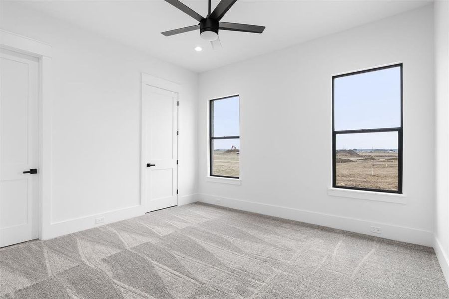 Unfurnished room with ceiling fan and light colored carpet