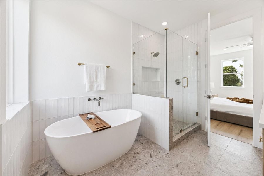 A separate soaking tub with wall mounted fixtures wonderfully compliments the frame-less glass shower with oversized shower head and bath supply inset shelf. A separate soaking tub with wall mounted fixtures wonderfully compliments the frame-less glass shower with oversized shower head and bath supply inset shelf.