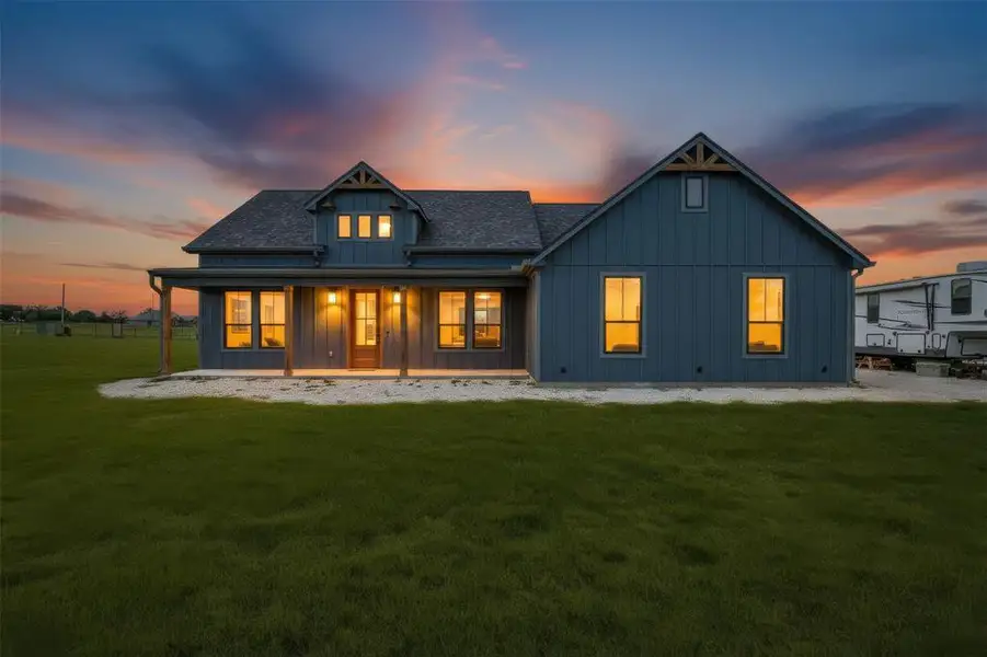 Craftsman-style home featuring a covered front porch with exposed timber columns, board and batten siding, multiple gabled rooflines, and a spacious front lawn