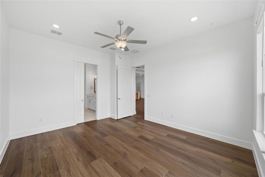 Spacious room featuring wood-finish flooring, white walls, and bright white trim
